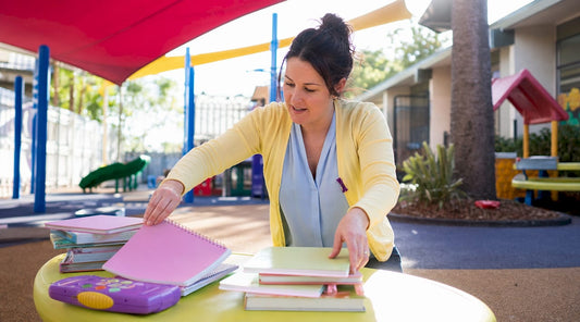 Educator examining handwriting learning materials in classroom
